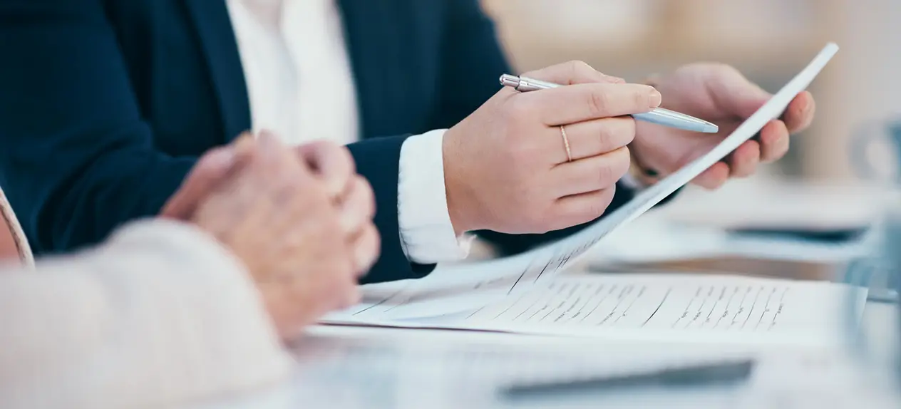 manos en una oficina con papeles y un bolígrafo