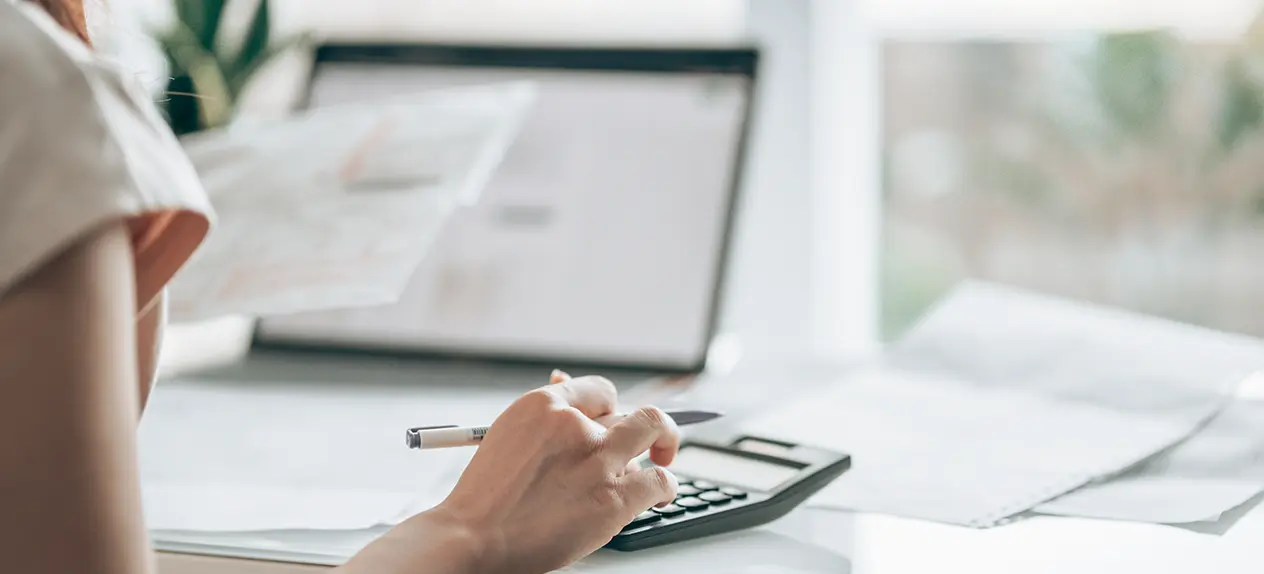 manos en una oficina con papeles y un bolígrafo